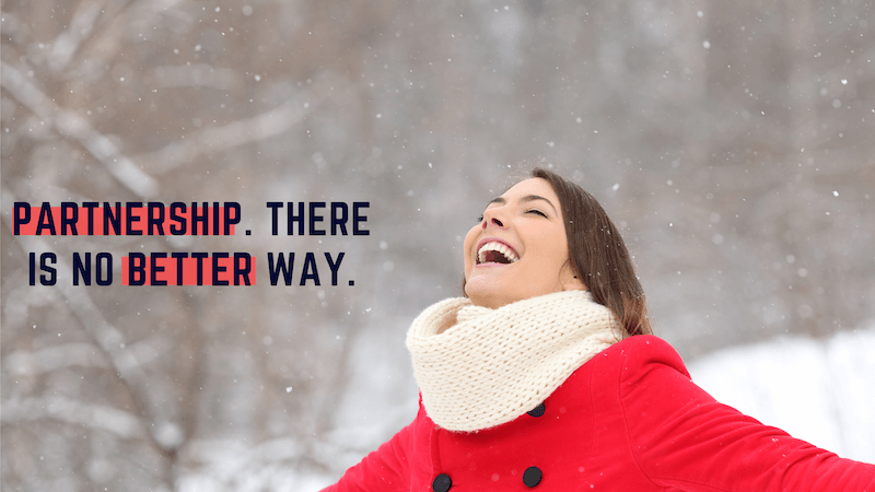 A woman in a snowy setting smiling up in the air